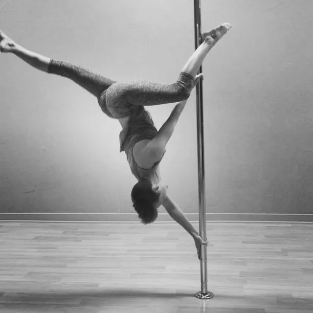 Khristen holding a butterfly pose on the pole